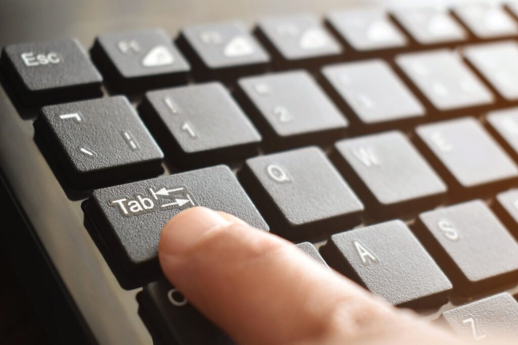 finger pressing tab key on keyboard